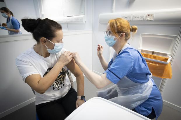 Cumnock Chronicle: Nurse Eleanor Pinkerton administers a coronavirus vaccine to one of the health and social care staff at the NHS Louisa Jordan Hospital  Picture: Jane BarlowPA Wire