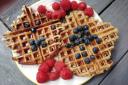Waffles topped with fruit and syrup. Credit: Canva