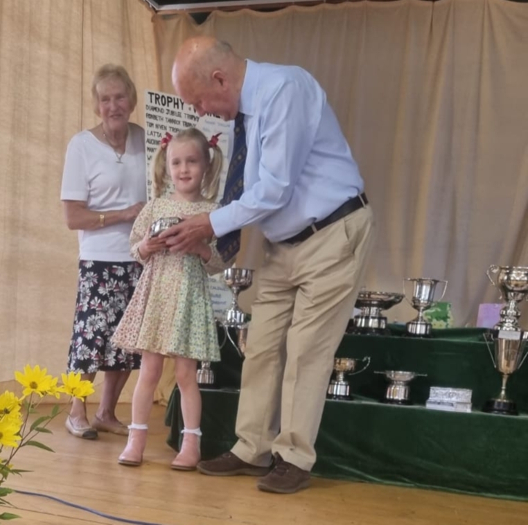 John Scott presents a trophy to junior winner Molly Robb